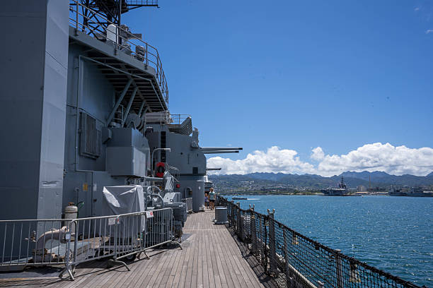Hawaii  United States June29, 2024:This photograph captures the imposing form of the USS Missouri, a historic battleship, docked in Honolulu. The image showcases the ship's massive size and powerful presence, highlighting its significance in naval history. The clear blue sky and calm water provide a dramatic backdrop for this symbol of American strength and resilience.