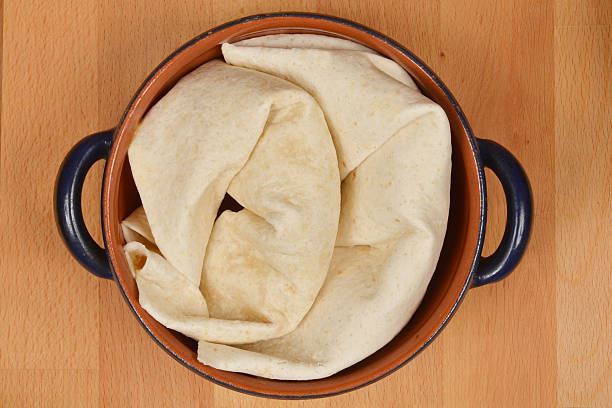 Pita tortilla lavash bread rolled into four, isolated on white background.