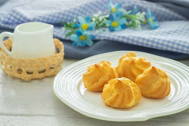 istock Cream puffs filled with vanilla custard cream on white plate 2208399163