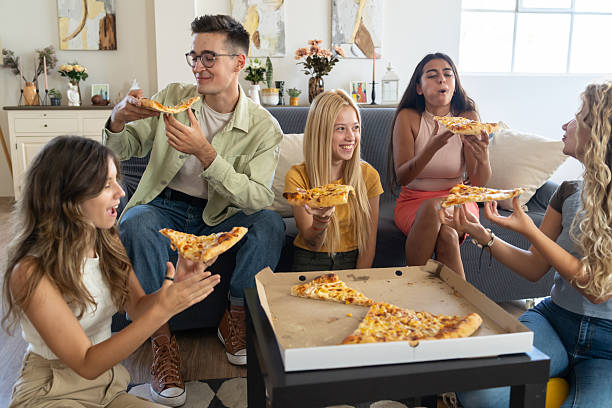 istock Friends having fun while eating pizza together 2208402400
