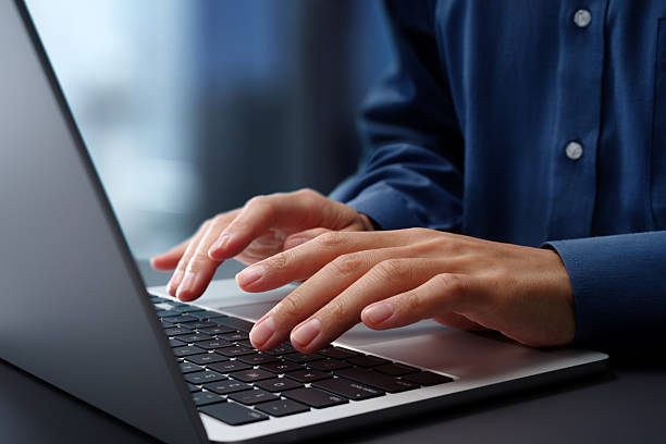 istock Hands typing on laptop computer keyboard. Businessman working at desk in office. Using technologies in business. 2208404593