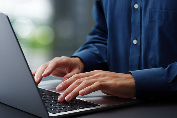istock Hands typing on laptop computer keyboard. Businessman working at desk in office. Using technologies in business. 2208404613