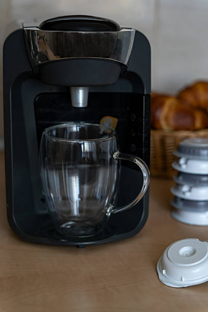 istock Capsule coffee maker with glass cup for latte and capsules for preparation in home kitchen. Home capsule coffee maker for aromatic coffee. 2208409395
