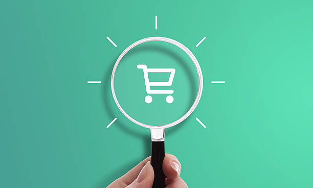 istock Hand holding magnifying glass with shopping cart icon 2208411523