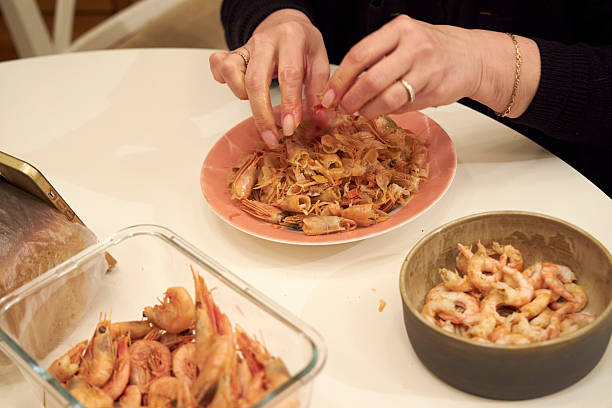 istock a woman peels shrimp at a white table in the kitchen 2208419653