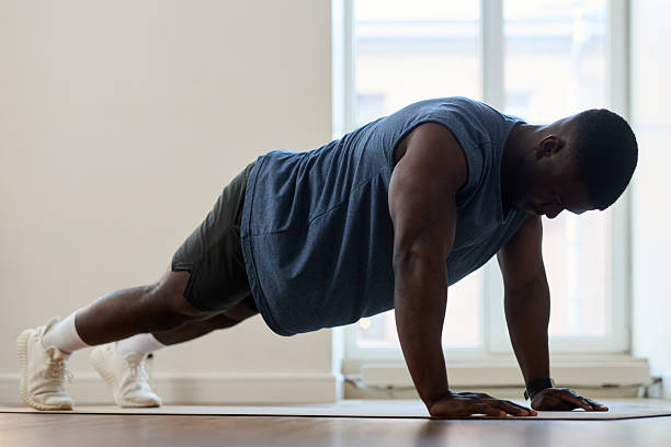 istock Exercising African American Man Doing Push-Ups Indoors 2208421002