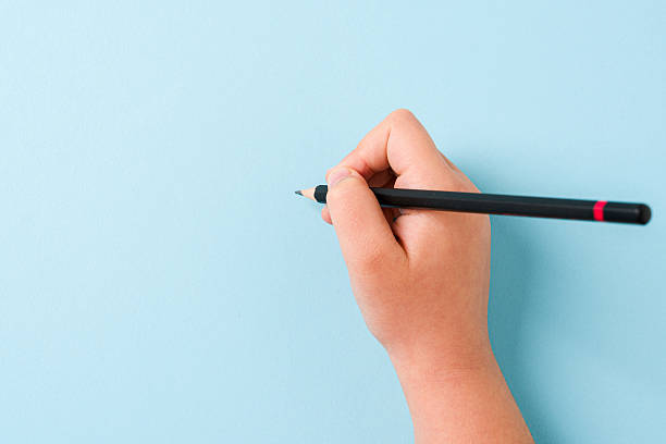 istock Girl holding pencil with right hand on blue background 2208423789