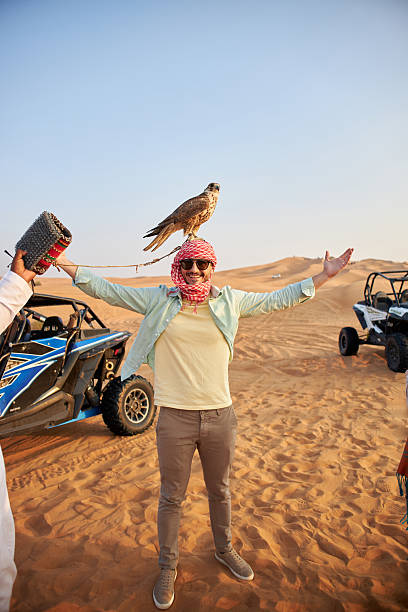 istock Handsome man holding falcon in Dubai desert 2208424892