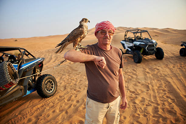Abu Dhabi - February 21, 2024: 4x4 SUV on top of the sand dune. Extreme sports and adventures. Scenic desert landscape