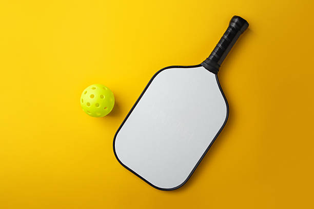 istock Pickleball Paddle and Ball on a yellow background 2208427657