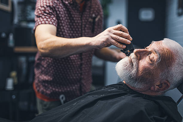 istock Senior man cutting his beard in barbershop 2208427877