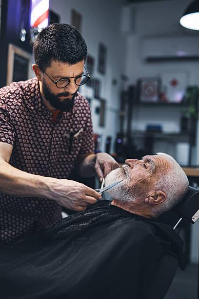 istock Senior man cutting his beard in barbershop 2208427887