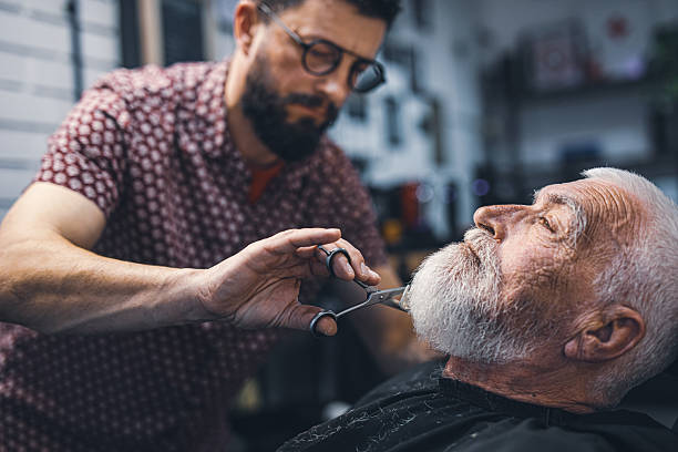 istock Senior man cutting his beard in barbershop 2208427926