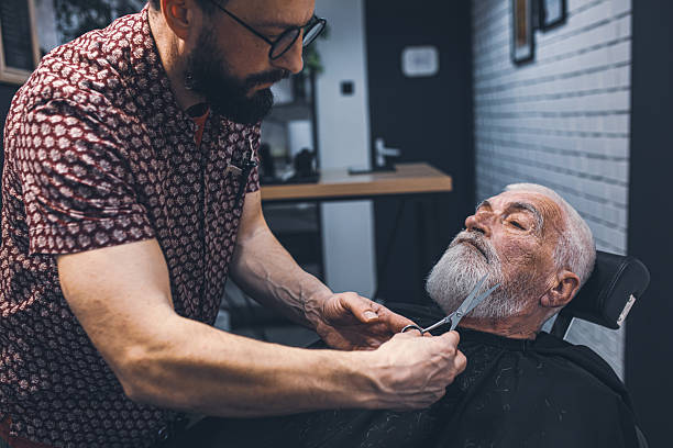 istock Senior man cutting his beard in barbershop 2208427936