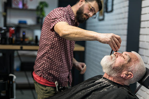 istock Senior man cutting his beard in barbershop 2208427947