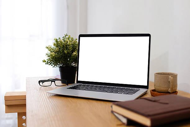 istock Laptop with blank screen placed on a work desk inside a white home interior. 2208428834