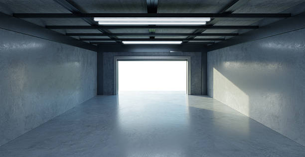 istock 3D Empty garage opening its gate showing a bright light at the end 2208434800
