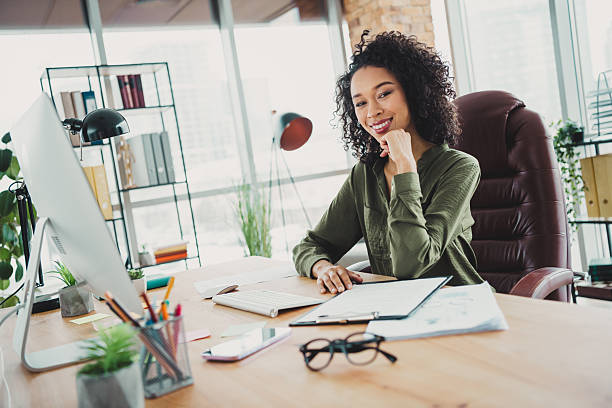istock Confident young businesswoman in a bright modern office workspace analyzing documents and planning her next successful professional project 2208436097