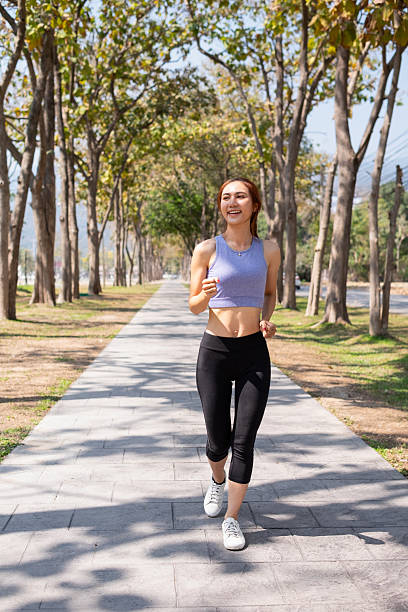 istock Woman running in a public park, morning sunlight 2208436974