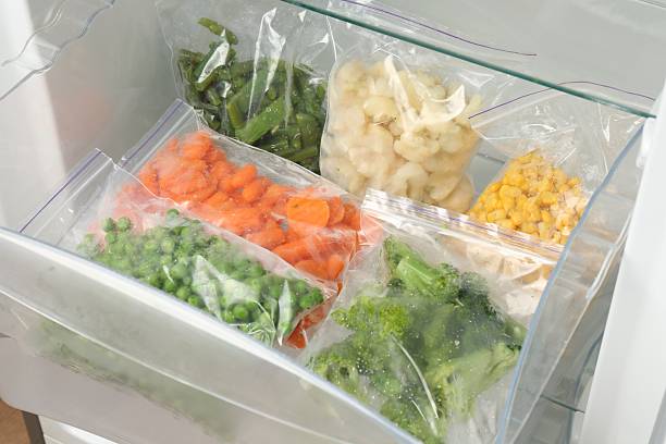 istock Plastic bags with different frozen vegetables in refrigerator 2208437185
