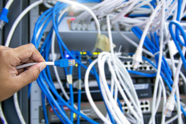 istock Close-up hand choose UTP LAN network cable and Lots of Ethernet cables background for connect computer and networking devices such as switch or hub modem router in rack cabinet. 2208439087