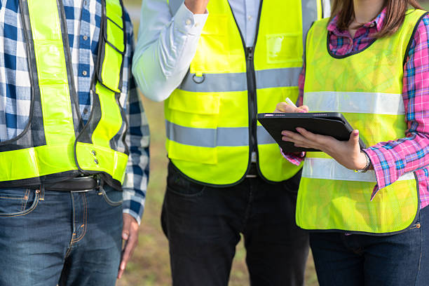 istock Three engineers in the energy industry discussing business goals and wind farm efficiency, using a walkie-talkie and tablet to coordinate real-time operations in a professional setting. 2208440940