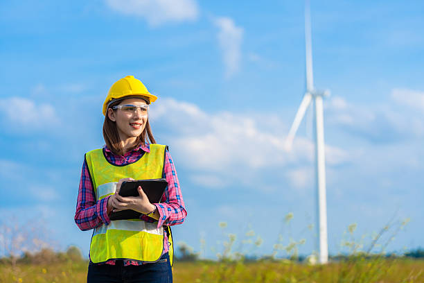 istock Professional female engineer in wind energy industry plans project and prepares to discuss business development, using radio for team coordination and tablet for project information. 2208441113