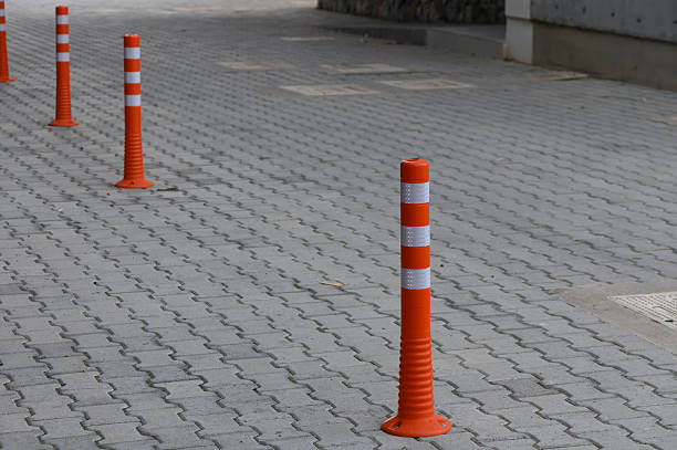 istock Orange traffic cones line a pedestrian pathway in a modern urban environment during daylight hours 2208441202