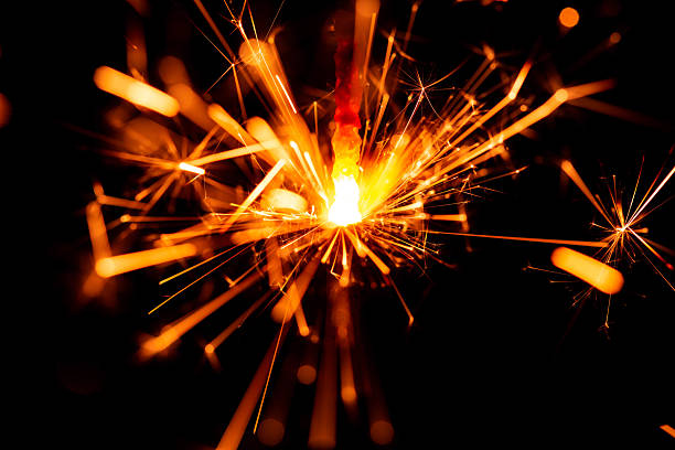 istock Close-Up of Sparkler Igniting with Bright Sparks in Dark Background 2208443580