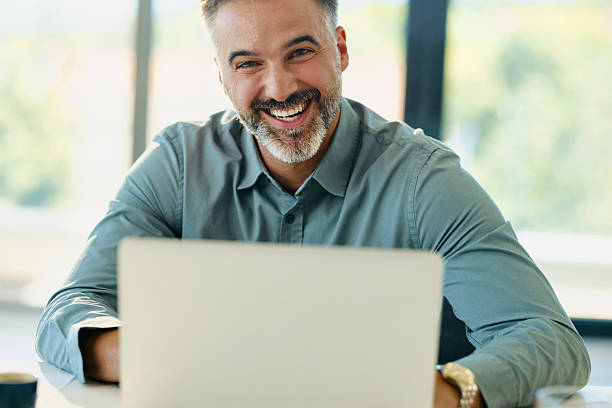 istock Happy businessman working on laptop in the office. 2208445203