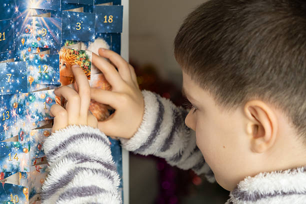 A child takes out a small chocolate from a Christmas advent calendar stock photo