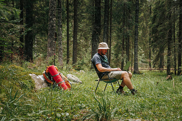 istock Young traveler works remotely in serene woodland setting 2208446676