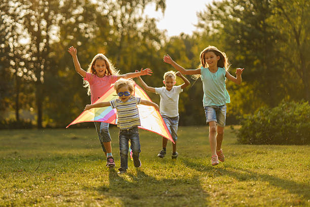 istock Children having fun while playing whit kite in park 2208449031