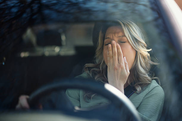 istock Tired woman yawning while driving a car. 2208450457