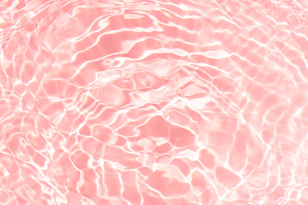 istock Pink water bubbles on the surface ripples. Defocus blurred transparent pink colored clear calm water surface texture with splash and bubbles. Water waves with shining pattern texture background 2208450882