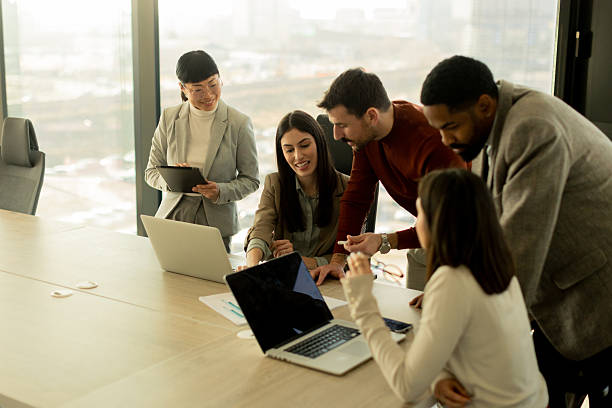 istock Collaboration thrives in a modern office with stylish professionals engaged in discussion 2208451099