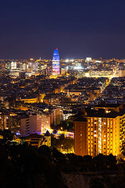 Elevated view of Barcelona city at night, captured from near the Carmel Bunkers, showcasing illuminated buildings and urban landscape.