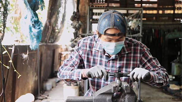 istock Front View Blue Collar Worker Using Die to Repair Damaged Ball Joint Thread 2208452315
