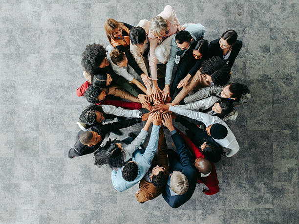 istock Professional colleagues in a collaborative huddle with hands united in solidarity 2208453072