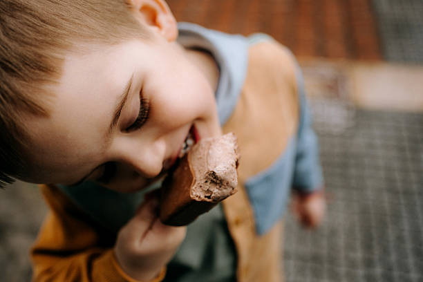 Summer and ice cream. Bright summer image with appetizing ice cream in the hands of a man in a red t-shirt.