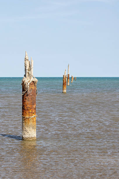 istock Weathered rusty posts rise from the shallow sea 2208453401