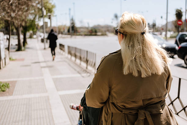 istock Rear view of mother pushing a stroller 2208453604