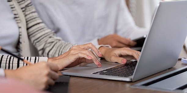 istock Collaboration and Engagement. Close-up of students actively typing and taking notes during a group study session. 2208454501
