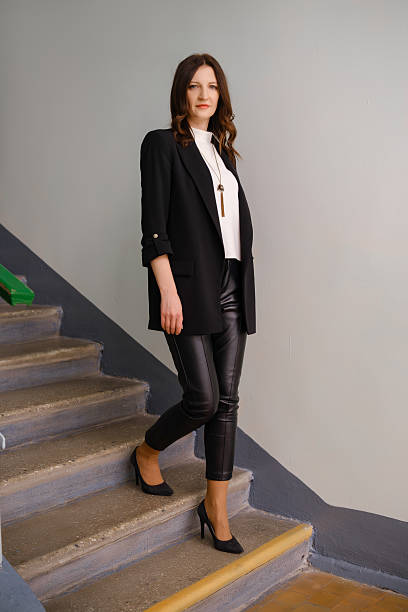 istock Woman in stylish outfit walking down staircase in modern setting during daytime 2208456030