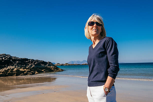 istock Woman walking on Camusdarach beach, Arisaig, Scotland. 2208456477