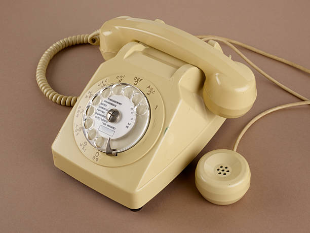 istock A beige rotary dial telephone with secondary earpiece and cables. 2208457303