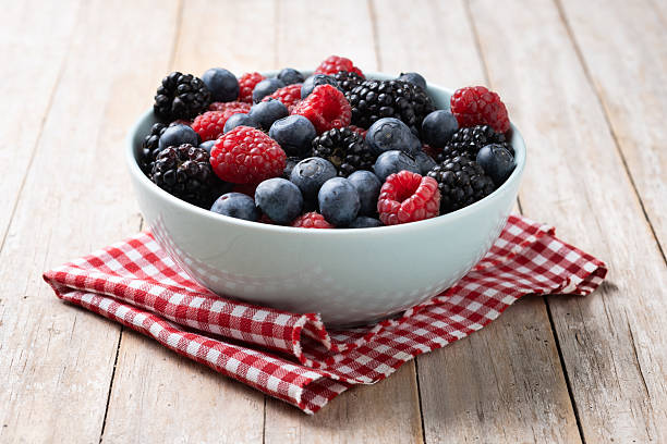 istock Fresh assortment berries in bowl on wooden table 2208457869