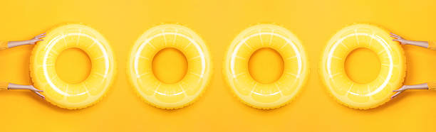 istock Summer cover banner with inflatable swim rings on yellow studio background 2208459813