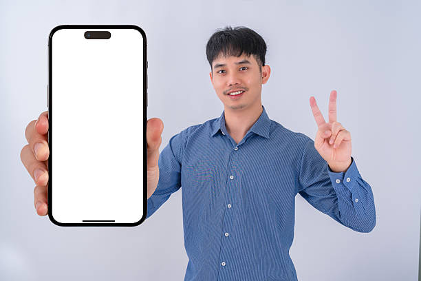 istock Young businessman showing big smartphone with blank screen. High quality studio shot. Concept for technology, business, finance and advertising. 2208462512