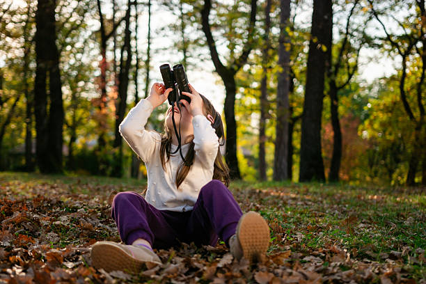 Girl watching birds with binoculars in nature